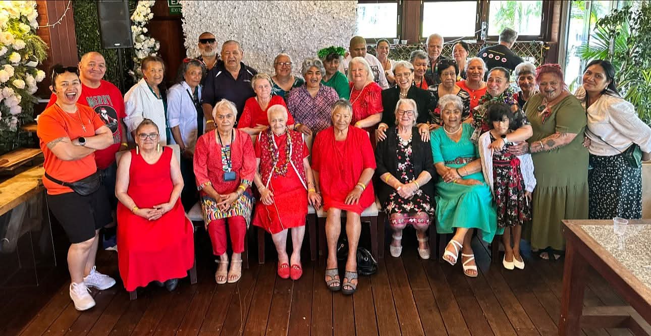 Aroha Seniors members and whānau gathered together, many dressed in red