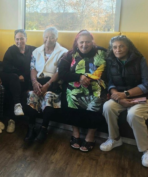 Four members sitting together on a booth seat
