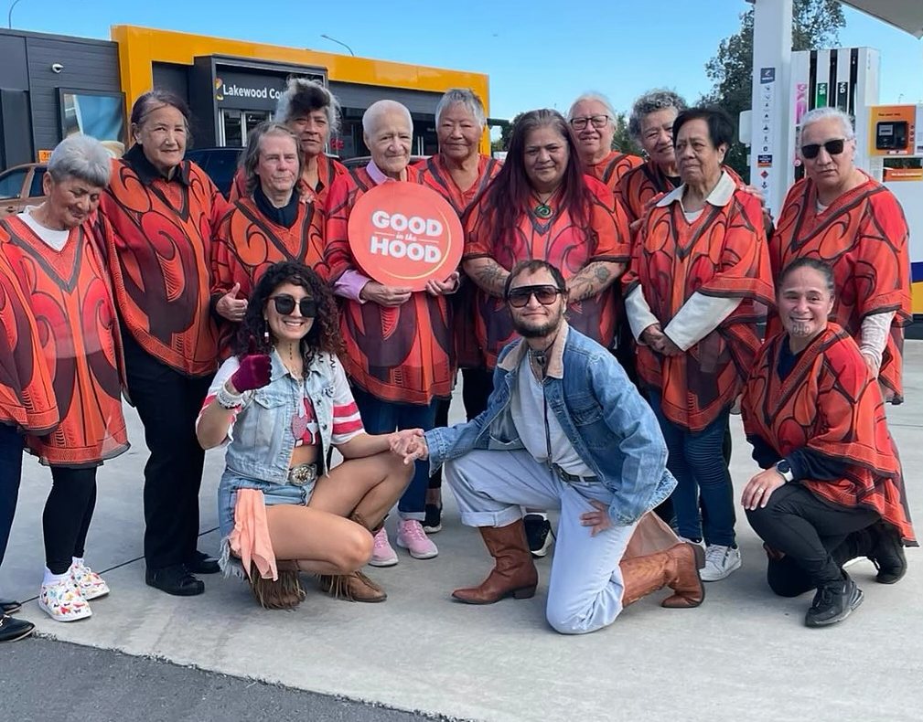 Aroha Seniors members together in matching red and black ponchos